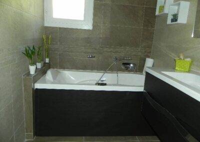 Réalisation INDECO CARRELAGE salle de bain baignoire, avec meuble effet bois wengé. Carrelage beige
