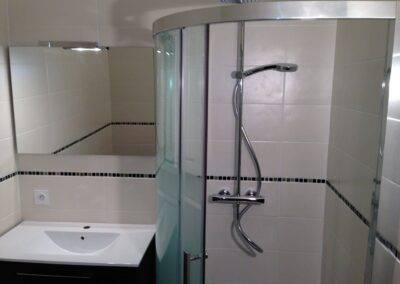 Réalisation INDECO CARRELAGE Salle de bain avec douche. Carrelage sol noir, carrelage mur beige. Meuble de salle de bain noir