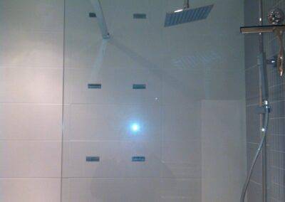 Réalisation INDECO CARRELAGE douche italienne carrelage gris et blanc. Paroi verre sur mesure