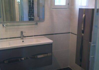 Réalisation INDECO CARRELAGE salle de bain carrelage au sol gris anthracite, carrelage au mur blanc. Meuble de salle de bain gris
