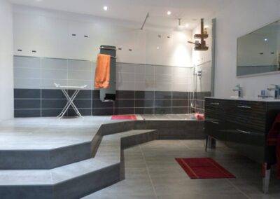 Réalisation INDECO CARRELAGE celle de mon carrelage gris clair et gris foncé douche italienne avec paroi de douche sur mesure réalisation salle de bain carrelage gris et meubles laqués blanc.