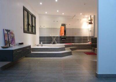 Réalisation INDECO CARRELAGE celle de mon carrelage gris clair et gris foncé douche italienne avec paroi de douche sur mesure réalisation salle de bain carrelage gris et meubles laqués blanc.